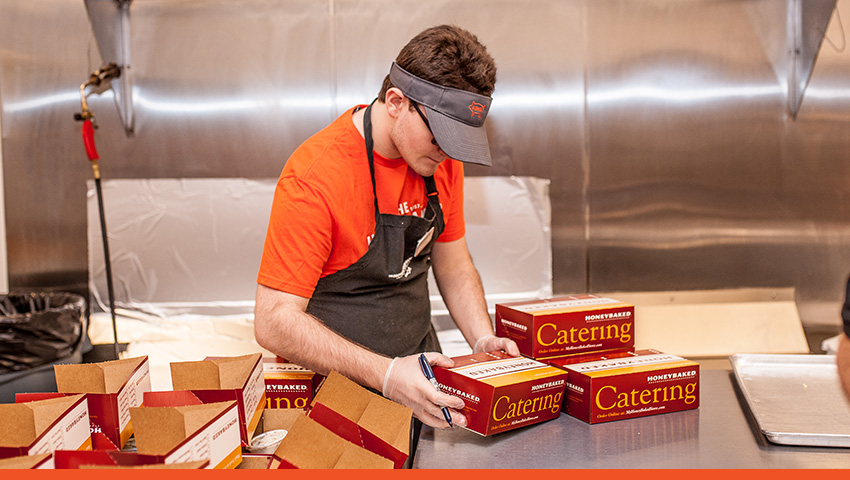 HoneyBaked employee packaging lunch