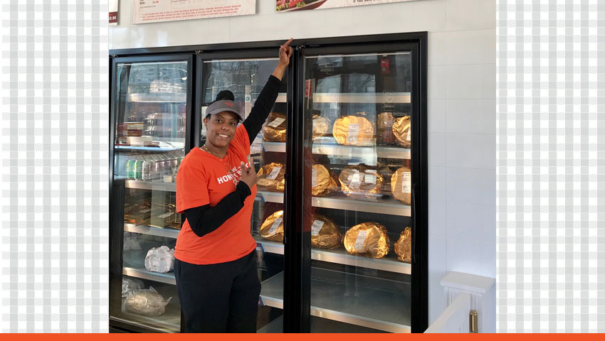 HoneyBaked Ham Franchisee standing by the fridges