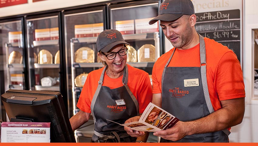 HoneyBaked Ham franchisees looking over branded materials