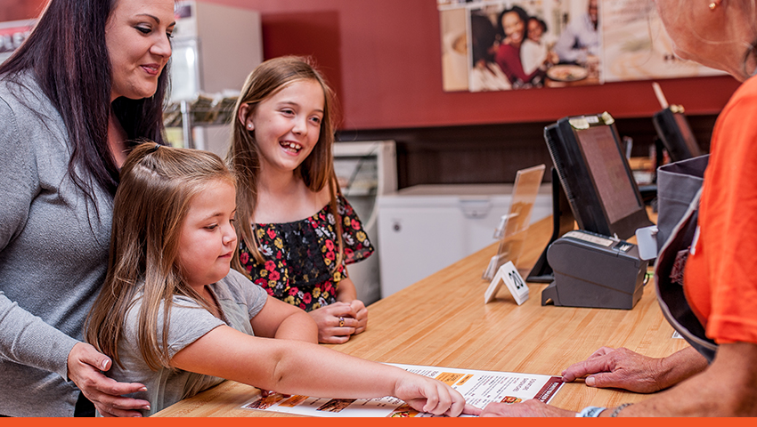 Image of HoneyBaked employee serving guests